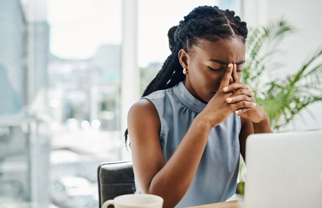 stressed businesswoman sitting in front of laptop