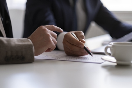 business person signing documents in an office