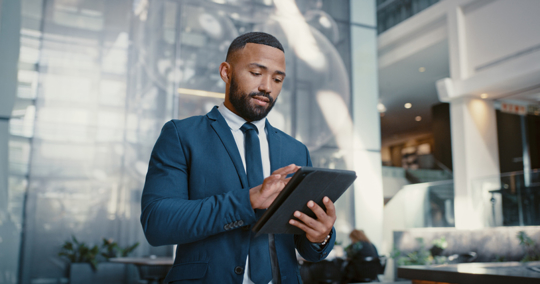 man in suit scrolling through tablet