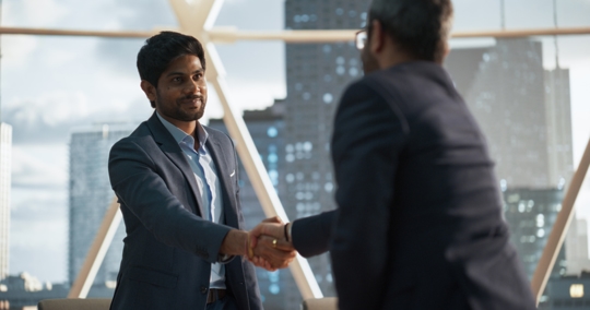 businesspeople shaking hands in an office