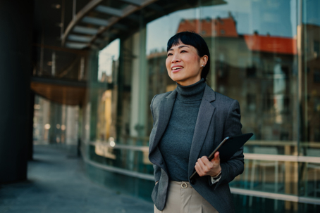 confident businesswoman standing outside office building